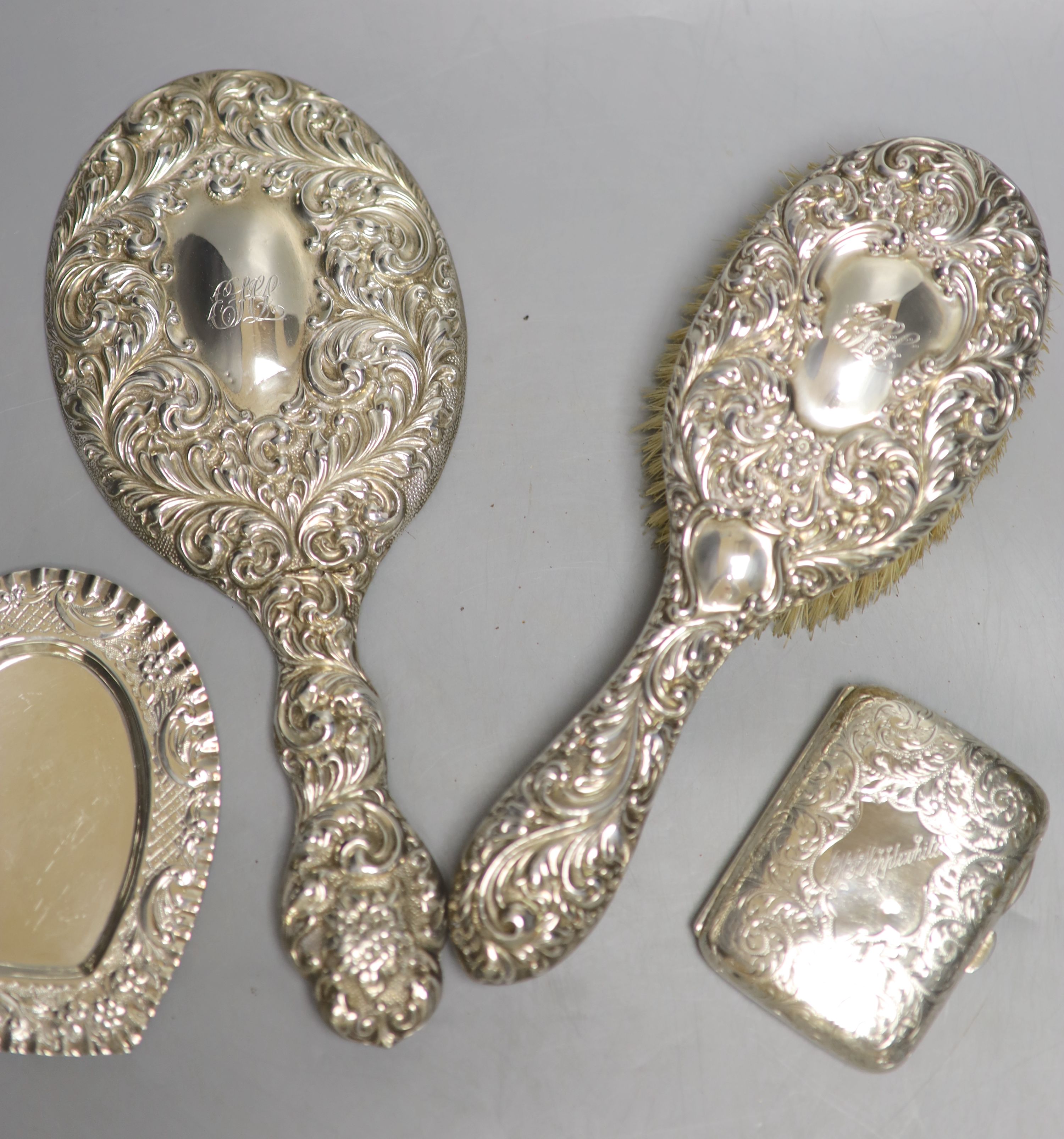 A silver cigarette case, a late Victorian silver heart shaped dish, a silver hand mirror and brush.